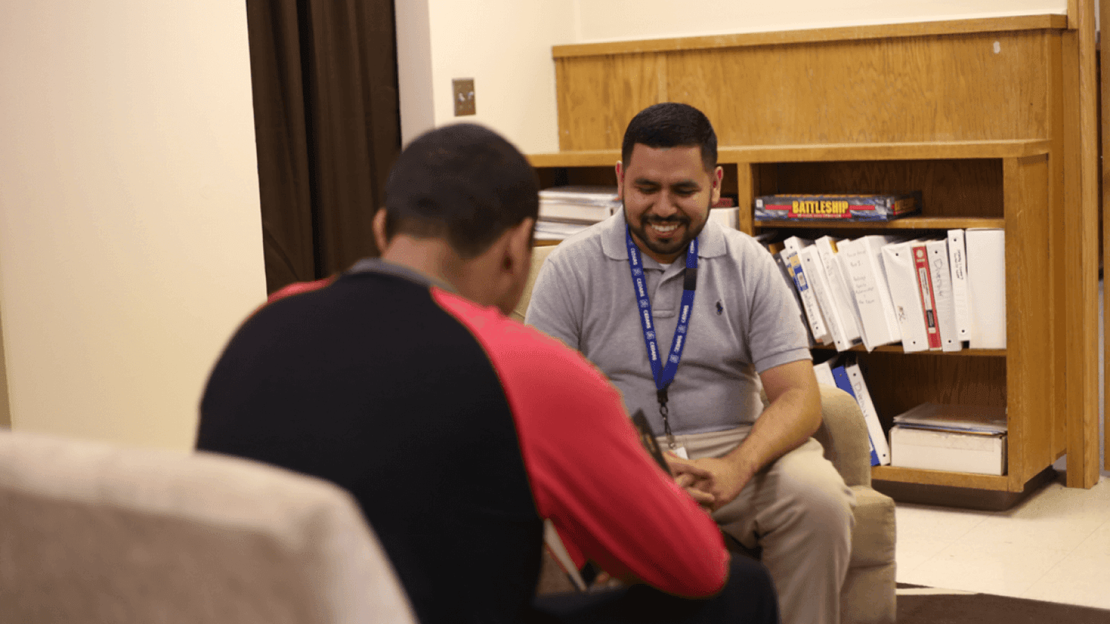 CEDARS staff member sitting across from a teen and smiling at them.