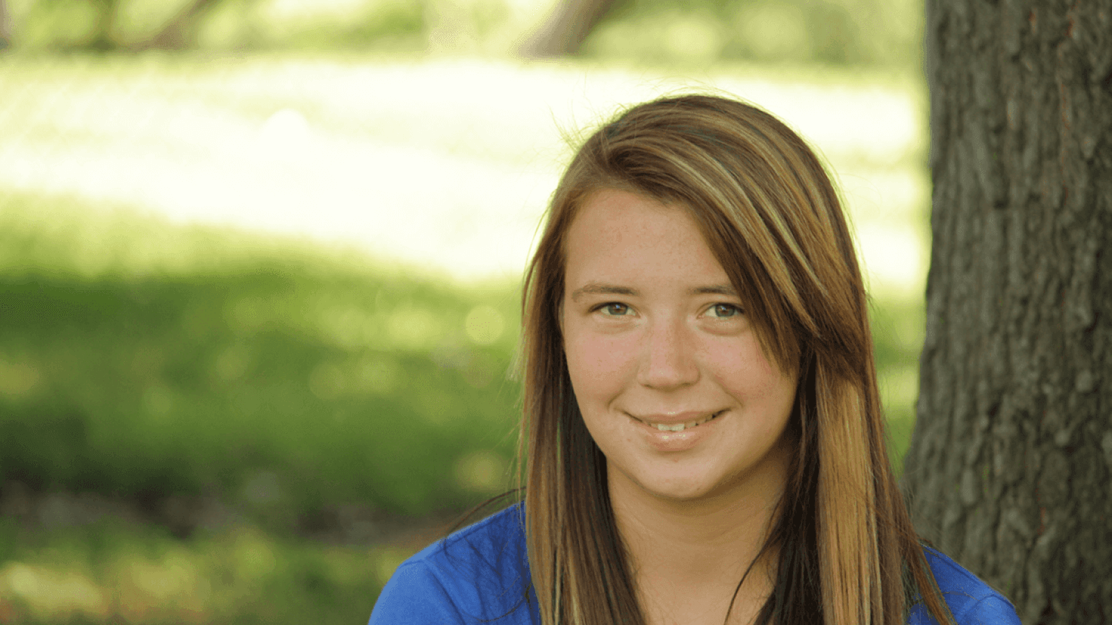 teen girl sitting outside and smiling