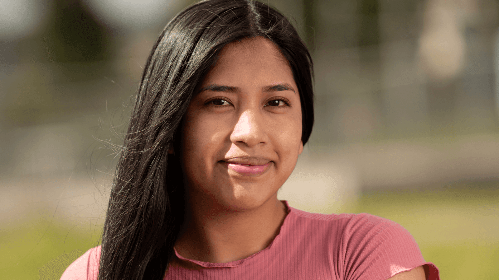 Teen girl with dark features smirking at the camera